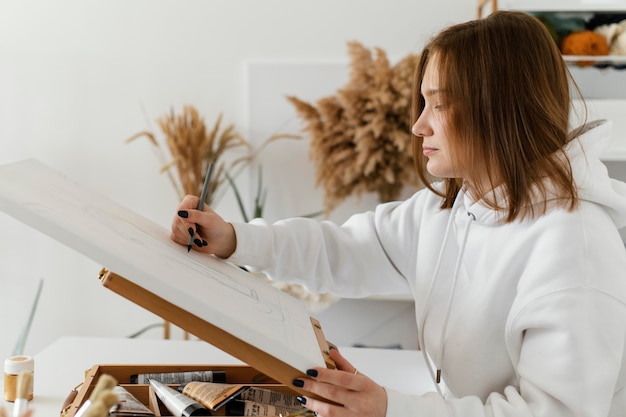 Gratis foto jonge vrouw die op een canvas trekt