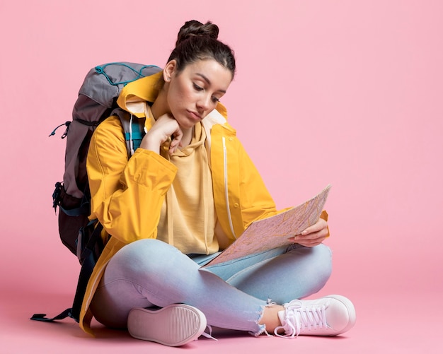 Gratis foto jonge vrouw die op een kaart zoekt