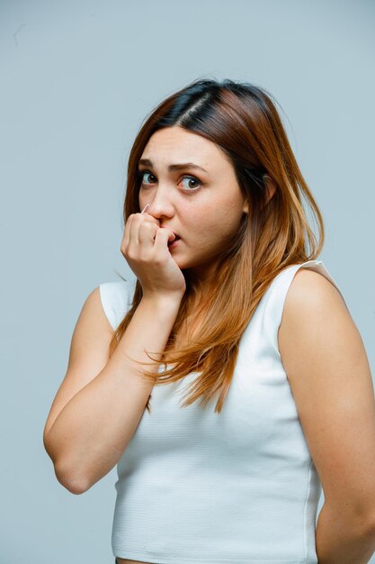 Jonge vrouw die op haar nagels bijt