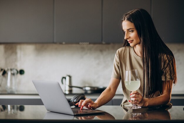 Jonge vrouw die op laptop van huis werkt