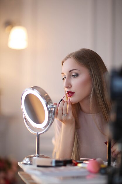 Jonge vrouw die op make-up zet.