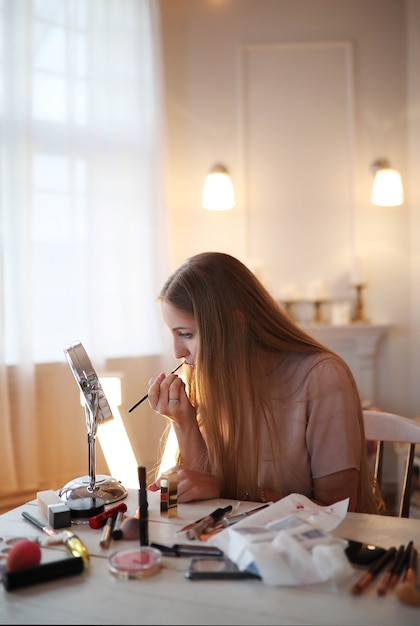 Jonge vrouw die op make-up zet.