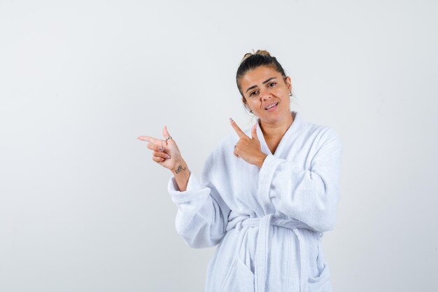 Jonge vrouw die opzij wijst in een badjas en er zelfverzekerd uitziet
