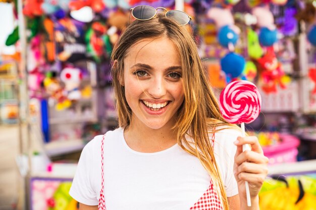 Jonge vrouw die rode lolly toont