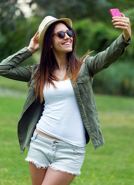 Jonge vrouw die selfie in park