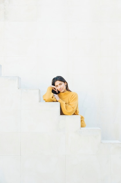 jonge vrouw die sweatshirt draagt die op stappen leunt