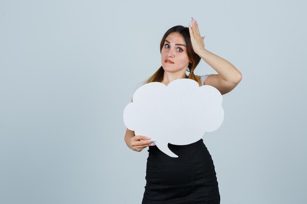 Jonge vrouw die tekstballon toont terwijl ze haar hand op haar hoofd houdt