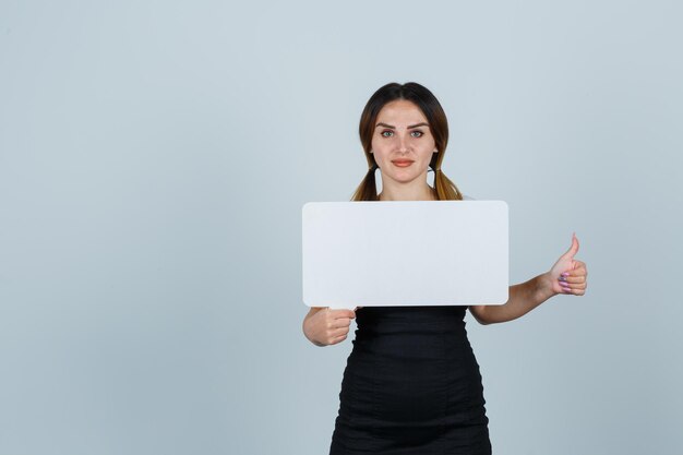 Jonge vrouw die tekstballon vasthoudt terwijl ze duimen laat zien