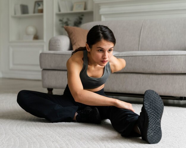 Jonge vrouw die thuis aan het trainen is