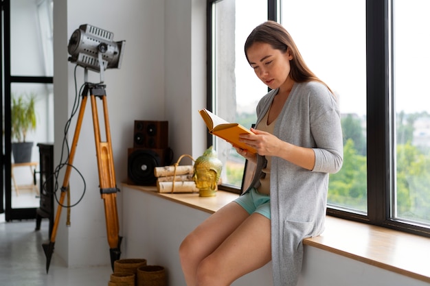 Jonge vrouw die thuis een boek leest