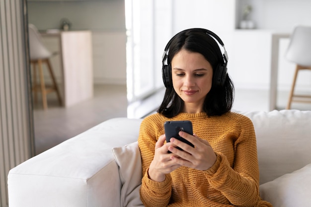 Jonge vrouw die thuis naar muziek luistert