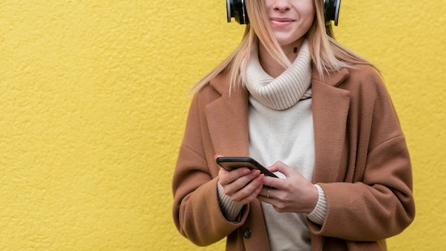 Jonge vrouw die van de muziek op haar hoofdtelefoons met exemplaarruimte geniet