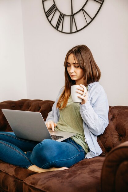 Jonge vrouw die van koffie laptop geniet