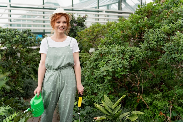 Jonge vrouw die voor haar planten zorgt