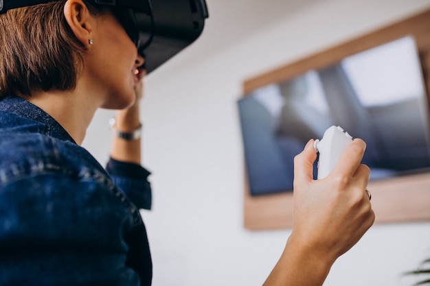 Jonge vrouw die vr-bril draagt en virtueel spel speelt dat ver gebruikt