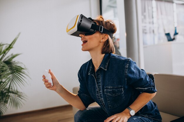 Jonge vrouw die VR-bril draagt en virtueel spel speelt dat ver gebruikt