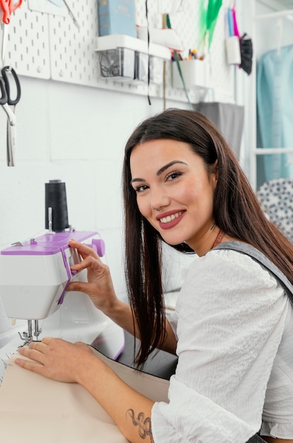 Gratis foto jonge vrouw die werkt in haar workshop modevormgeving