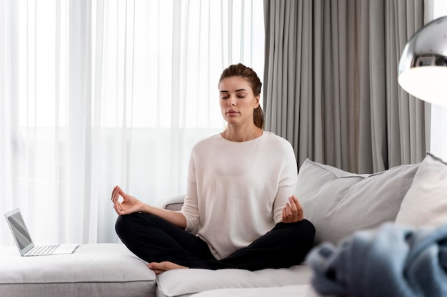 Gratis foto jonge vrouw die yoga beoefent om te ontspannen