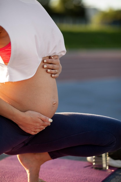 Jonge vrouw die yoga doet tijdens de zwangerschap