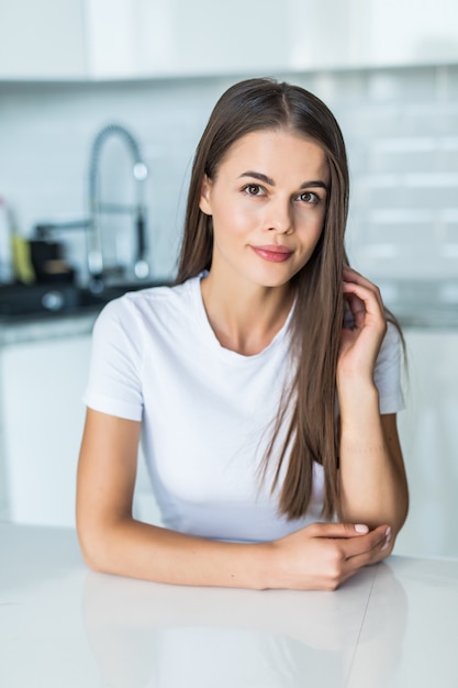 Jonge vrouw die zich dichtbij bureau in keuken bevindt.