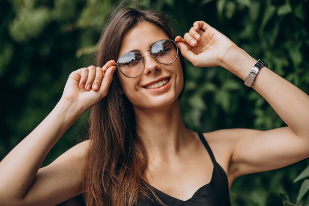 Jonge vrouw die zich door de groene struiken bevindt