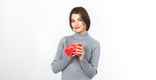 Jonge vrouw die zich met kop en klein hart bevindt