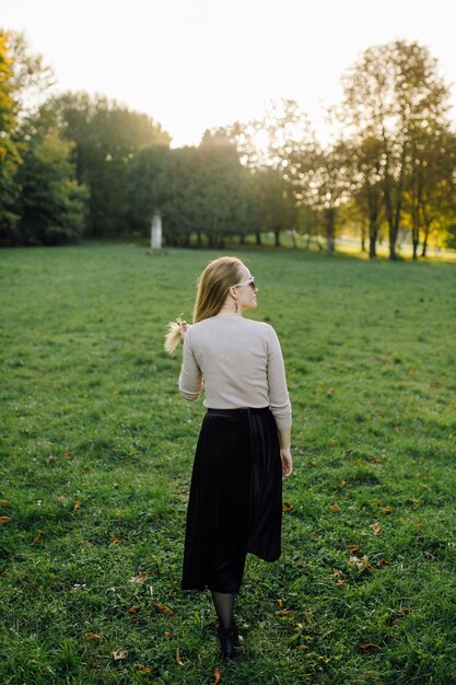 Jonge Vrouw Die Zich Voordeed Op Gele Bladeren In De Herfst Park. Buitenshuis