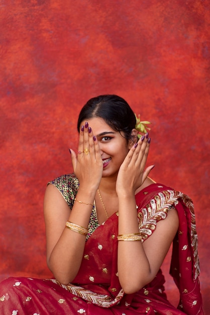 Jonge vrouw die zich voordeed terwijl ze een traditioneel sari-kledingstuk draagt
