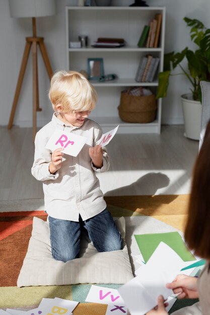 Jonge vrouw doet logopedie met een kleine jongen