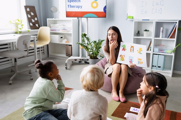 Jonge vrouw doet logopedie met kinderen