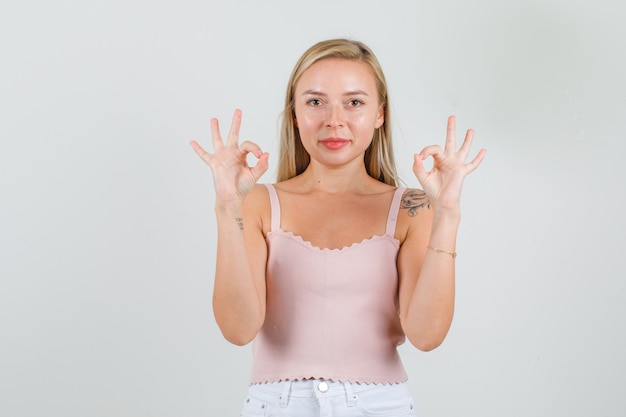 Jonge vrouw doet ok teken en lachend in hemd