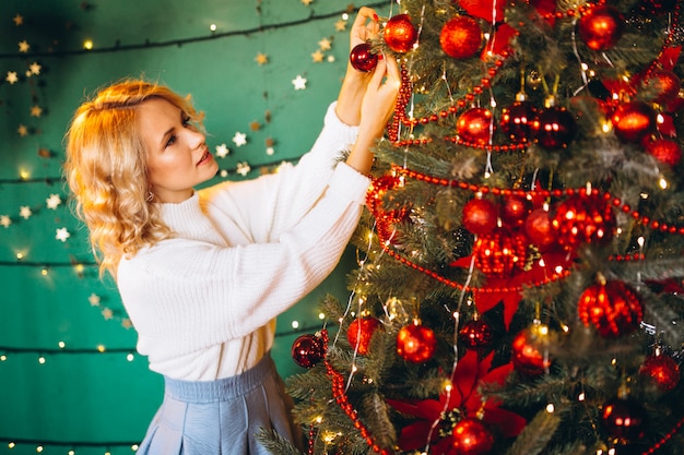 jonge vrouw door de kerstboom op Kerstmis
