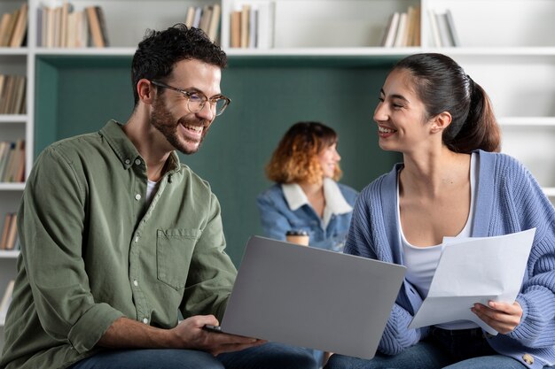 Jonge vrouw en man lezen van aantekeningen tijdens studiesessie