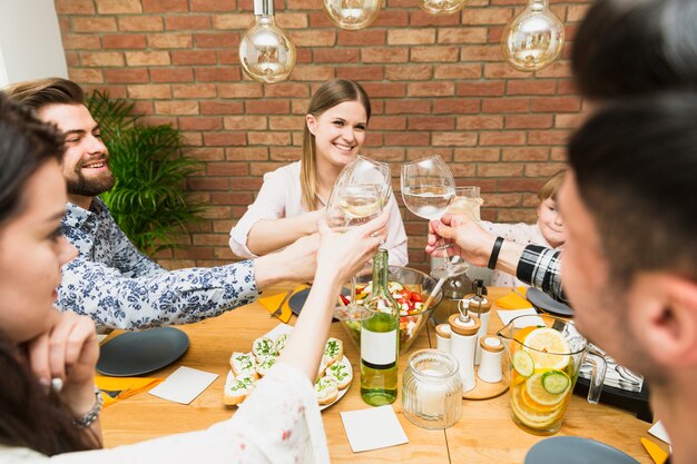 Gratis foto jonge vrouw en vrienden rammelende wijnglazen