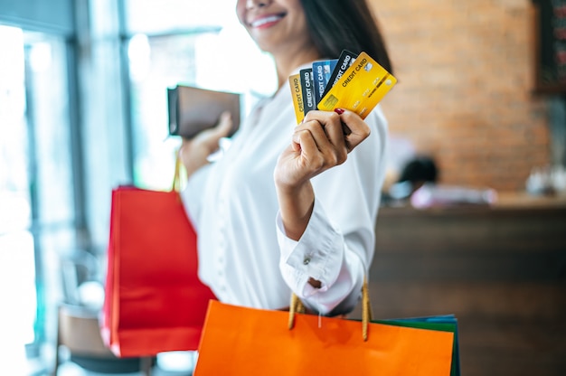 Jonge vrouw geniet van winkelen met creditcards.