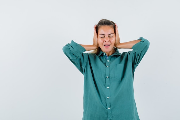 Jonge vrouw hand in hand op haar oren in blauw shirt en terughoudend op zoek