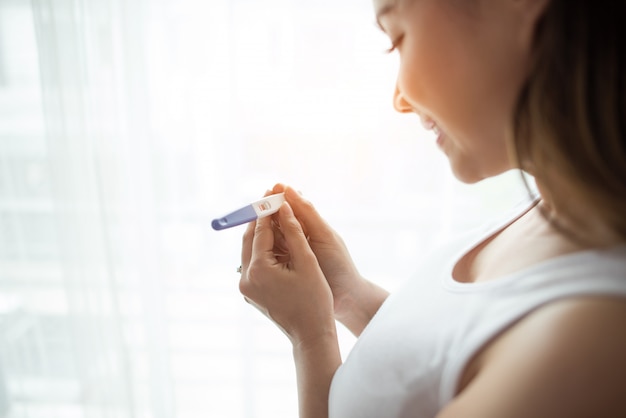 Jonge vrouw hand met zwangerschapstest