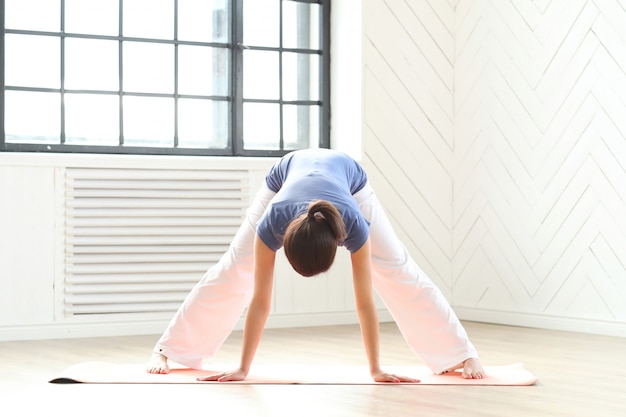 Jonge vrouw het beoefenen van yoga op een yogamat