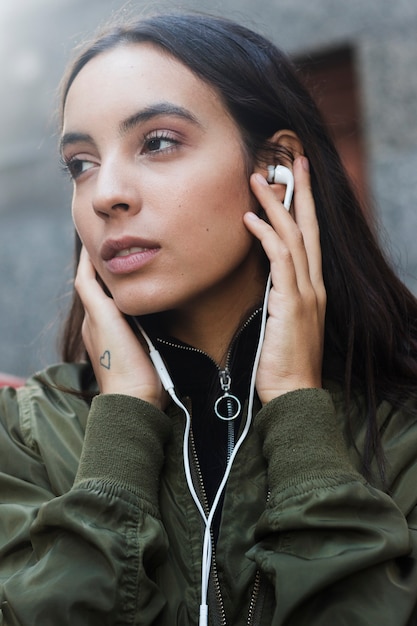 Jonge vrouw het luisteren muziek op oortelefoon