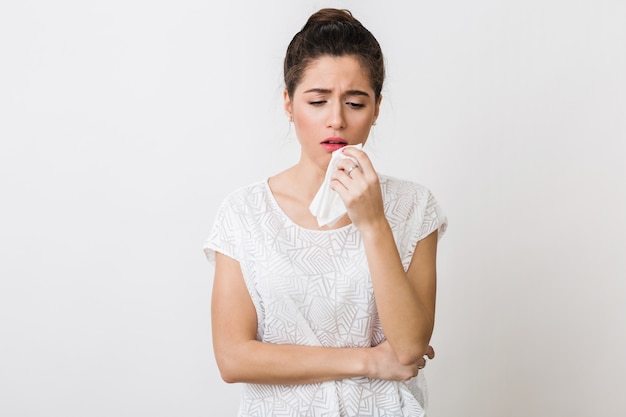 Jonge vrouw hoesten met een servet, verkouden, ziek voelen ,, geïsoleerd