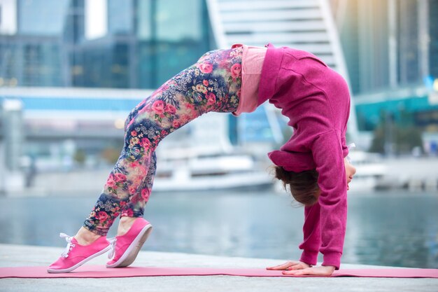 Gratis foto jonge vrouw in de brug staat tegen de stad en de rivier