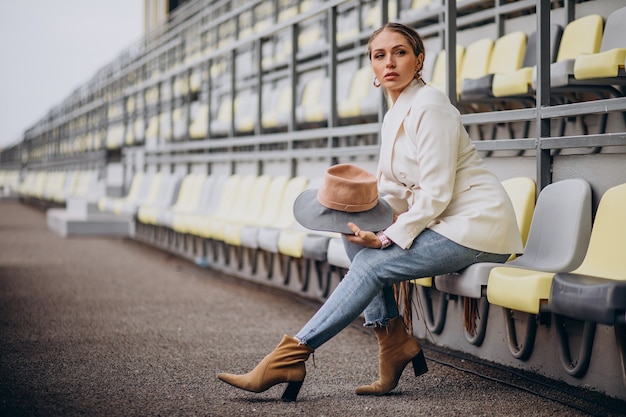 Jonge vrouw in de witte hoed van de jasjeholding