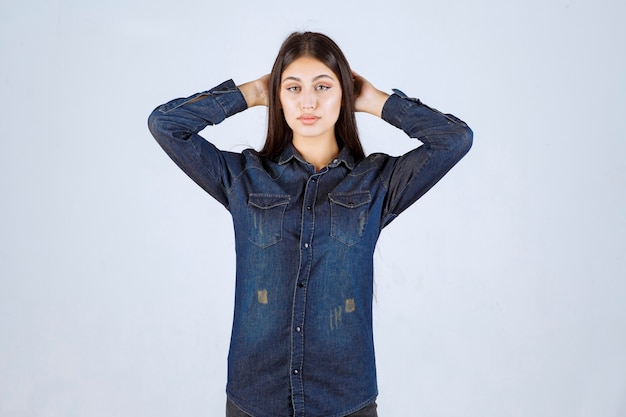 Jonge vrouw in denim overhemd neutrale en verleidelijke poses geven zonder reacties