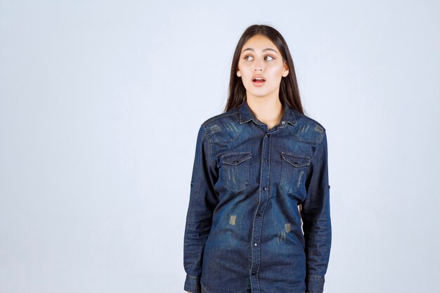 Jonge vrouw in denim overhemd neutrale poses geven zonder reacties