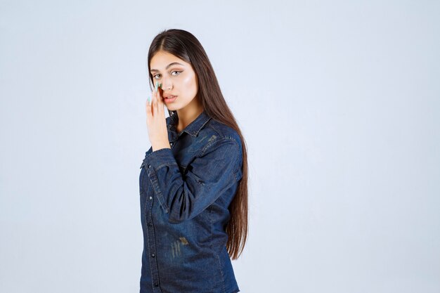 Jonge vrouw in denimoverhemd roddelen en geheim praten