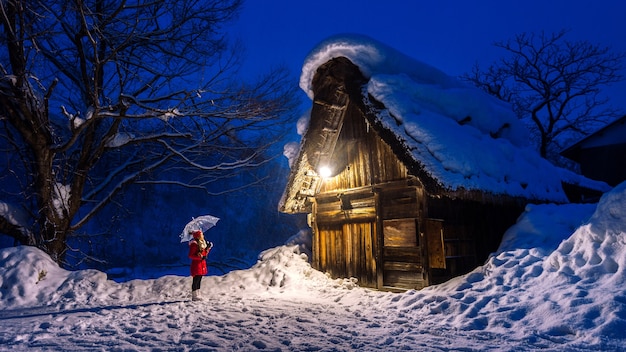 Jonge vrouw in dorp Shirakawa-go in de winter, Japan.