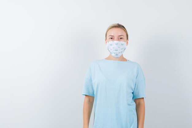Jonge vrouw in een blauw t-shirt met een medisch masker