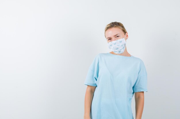 Jonge vrouw in een blauw t-shirt met een medisch masker