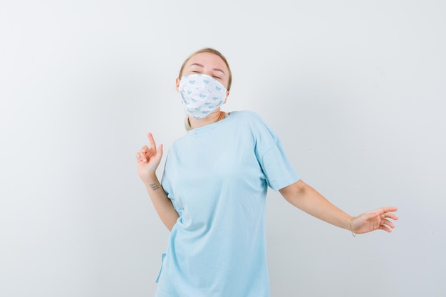 Jonge vrouw in een blauw t-shirt met een medisch masker