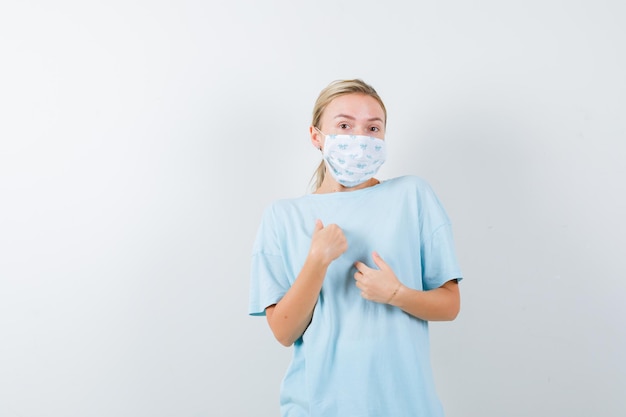 Jonge vrouw in een blauw t-shirt met een medisch masker